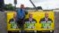 African National Congress (ANC) election posters featuring images of South Africa's President Jacob Zuma are displayed on a wall as a school boy climbs over it in Embo, May 6, 2014.