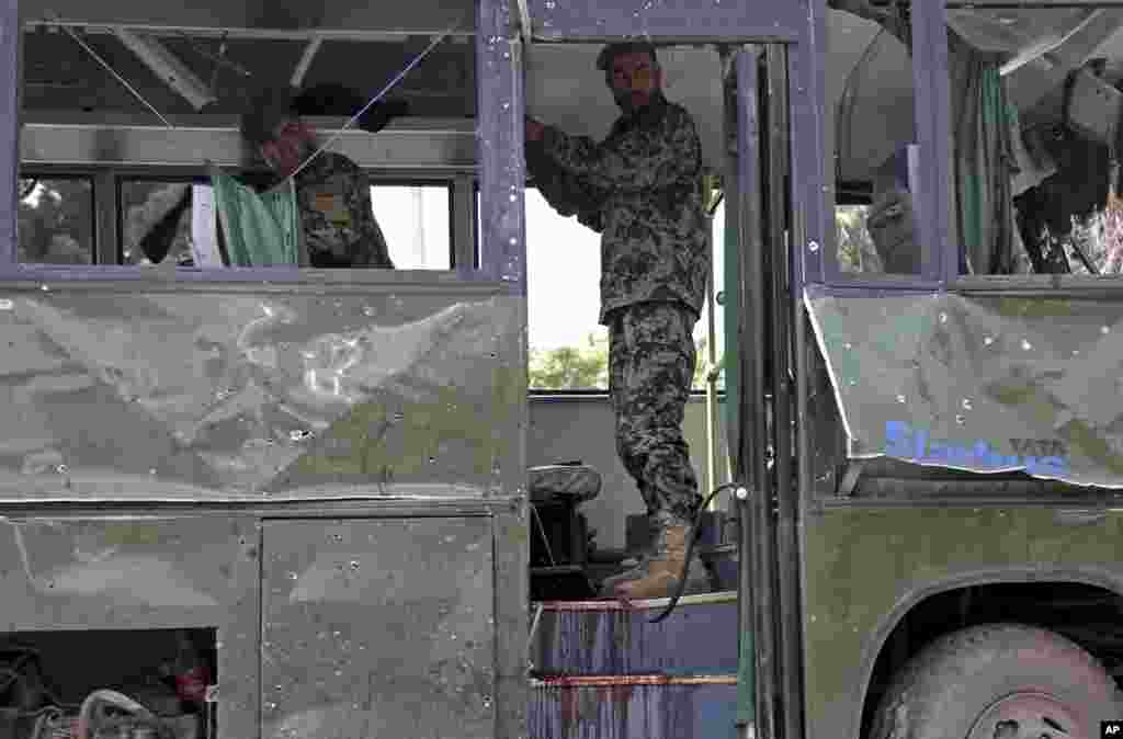 Afghan National Army soldiers prepare to remove a destroyed military bus after a suicide attack in Kabul, June 2, 2014.