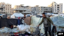 People inspect the site of reported Israeli bombardment on tents sheltering Palestinians displaced from Beit Lahia at a camp in Khan Yunis in the southern Gaza Strip on Dec. 25, 2024.