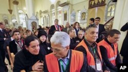 A Syrian woman (L) speaks with an Arab league observer, (R) who attends with other observers a mass prayer for the people and army soldiers who were killed during the violence around the country, at the Holy Cross Church, in Damascus, January 9, 2012