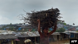 Rohingya refugee child carries wood as rain falls at Jamtoli refugee camp in Ukhia 