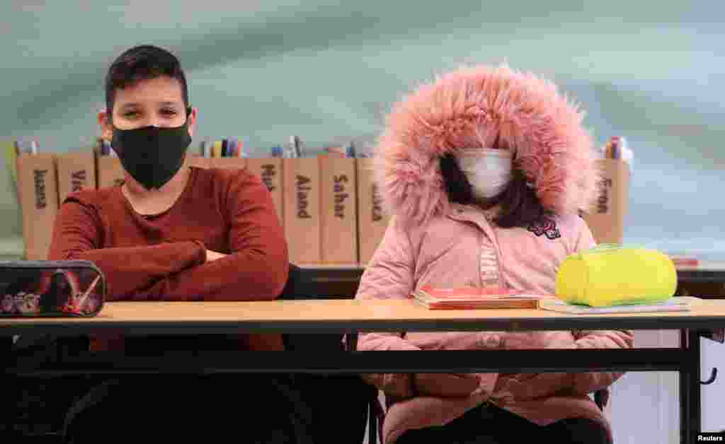 A student of Freiherr-vom-Stein secondary school in the North Rhine-Westphalian city wears a winter outfit against the cold as classes resume with open windows and protective masks against the spread of COVID-19 in Bonn, Germany.