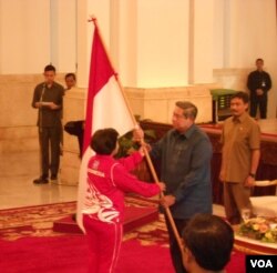 Presiden Susilo Bambang Yudhoyono menyerahkan bendera kepada Ketua Olimpiade Indonesia (KOI) Rita Subowo (15/7).