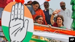 Congress party General Secretary and eastern Uttar Pradesh state in-charge Priyanka Gandhi Vadra, right, waves to party workers as she undertakes a steamer ride in the River Ganges from Manaiya, 25 kilometers (15.6 miles) from Prayagraj, India, March 18, 2019.