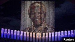 Candles are lit under a portrait of former South African President Nelson Mandela in his ancestral village of Qunu, Dec. 15, 2013.