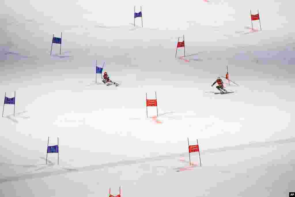 Austria's Christian Hirschbuehl, left, competes alongside Norway's Henrik Kristoffersen during an alpine ski men's World Cup parallel event, in Lech/Zuers, Austria.