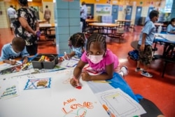 FILE — In this Aug. 17, 2021 file photo, students write and draw positive affirmations on poster board at P.S. 5 Port Morris, an elementary school in The Bronx borough of New York. New York City wants to phase out its program for gifted and talented students