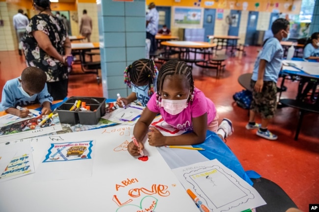 FILE — In this Aug. 17, 2021 file photo, students write and draw positive affirmations on poster board at P.S. 5 Port Morris, an elementary school in The Bronx borough of New York. New York City wants to phase out its program for gifted and talented students