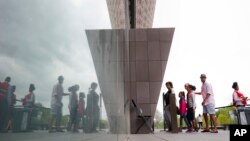 Visitors are reflected as they enter the Smithsonian National Museum of African American History and Cultural on the National Mall in Washington, May 1, 2017.