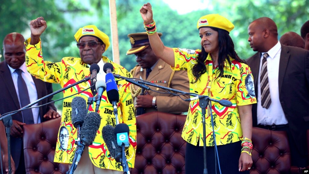 Zimbabwe's President Robert Mugabe, left, and his wife Grace chant the party's slogan during a solidarity rally in Harare, Wednesday, Nov. 8, 2017. 
