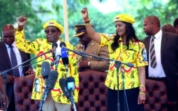 FILE: Zimbabwe's President Robert Mugabe, left, and his wife Grace chant the party's slogan during a solidarity rally in Harare, Wednesday, Nov. 8, 2017.