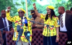 FILE: Zimbabwe's President Robert Mugabe, left, and his wife Grace chant the party's slogan during a solidarity rally in Harare, Wednesday, Nov. 8, 2017.