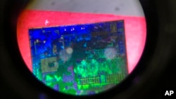  FILE - A Chinese microchip is seen through a microscope at the 21st China Beijing International High-tech Expo in Beijing on May 17, 2018. 