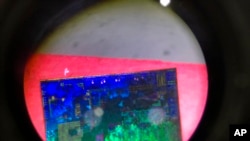  Un semiconductor chino visto a través de un microscopio en la 21 Exposición Internacional de Alta Tecnología de Beijing en 2018.
