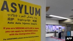 Un panneau parle du statut d'asile au bureau de l'immigration à l'aéroport international de Narita, au Japon, le 28 avril 2017.