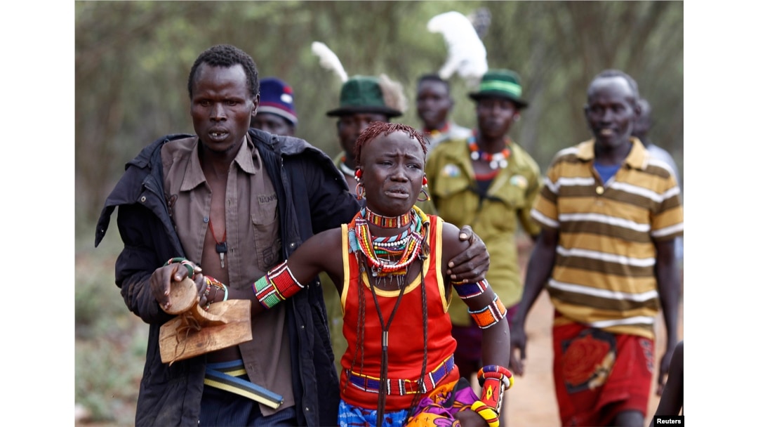 A man holds onto a girl as he brings her back to her family home after she tried to escape when she realized she is to be married, about 80 km (50 miles) from the town of Marigat in Baringo County, Dec. 7, 2014.