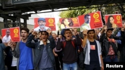 Members of the left-wing Labour Party (EMEP) carry pictures of the victims of Saturday's bomb blasts during a commemoration in Ankara, Oct. 11, 2015.