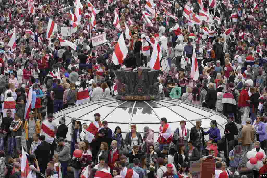 Opposition supporters with old Belarusian national flags rally at Independence Square in Minsk.