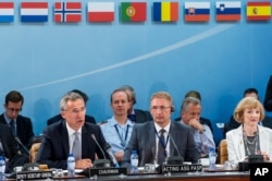 NATO Secretary General Jens Stoltenberg, left, talks during a North Atlantic Council Meeting at NATO headquarters in Brussels on Tuesday July 28, 2015.