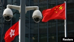 资料照：在香港政府总部大楼外监控摄像头后的中国国旗和香港特区旗帜。