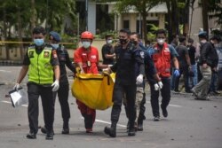 Polisi membawa tas berisi jasad terduga pelaku bom bunuh diri pasca ledakan di luar sebuah gereja di Makassar pada 28 Maret 2021. (Foto: AFP/Indra Abriyanto)