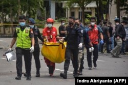 Polisi membawa tas berisi jasad terduga pelaku bom bunuh diri pasca ledakan di luar sebuah gereja di Makassar pada 28 Maret 2021. (Foto: AFP/Indra Abriyanto)