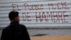 Un hombre pasa frente a un grafitis en protesta contra el hambre, en Caracas, Venezuela, agosto de 2018. Archivo.