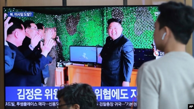 人们在韩国首尔火车站观看电视，电视上播放了朝鲜领导人金正恩在新闻节目中报道朝鲜导弹发射的照片。(2019年5月5日)