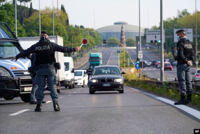 Oficiales de policía detienen automóviles en un punto de control en una calle de Roma el 13 de abril de 2020.