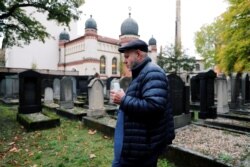Kepala komunitas Yahudi Halle, Max Privorozki, memegang lilin saat dia berjalan di pemakaman di sinagoga di Halle, Jerman 10 Oktober 2019, setelah dua orang tewas dalam penembakan. (Foto: REUTERS/Fabrizio Bensch)