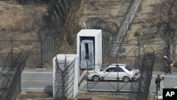A South Korean tourist in his own car enters the Demilitarized Zone (DMZ) to cross border separating the two Koreas in Goseong, far northeast of South Korea as soldiers wave, March 17, 2008
