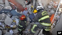 Regu pemadam kebakaran dari sektor Tacubaya dan para pekerja lainnya melakukan pencarian korban dengan menggali bangunan yang runtuh akibat ledakan di kantor pusat perusahaan minyak negara Meksiko, PEMEX, 31 Januari 2013. (AP Photo/Guillermo Gutierrez).