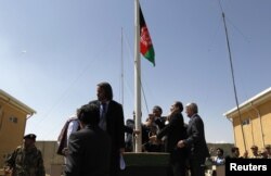 FILE - Afghan officials raise their national flag during a ceremony to hand over the Bagram prison to Afghan authorities, at the U.S airbase in Bagram, north of Kabul, September 10, 2012.