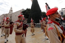 Members of a Palestinian marching band parade at Manger Square, in Bethlehem in the Israeli-occupied West Bank November 28, 2020. (REUTERS/Mussa Qawasma)