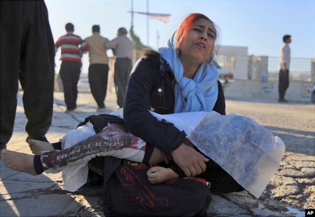 A woman mourns as she holds the body of her daughter, who died in an earthquake, in Sarpol-e-Zahab, western Iran, Nov. 13, 2017.