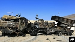 Destroyed military vehicles are seen at a naval military facility after coalition air strikes in People's Port in eastern Tripoli, March 22, 2011