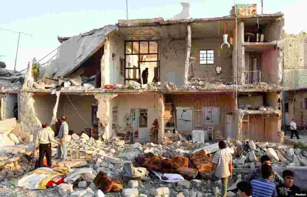 A man searches among houses that were destroyed during a recent Syrian Air Force air strike in Azaz, August 15, 2012.