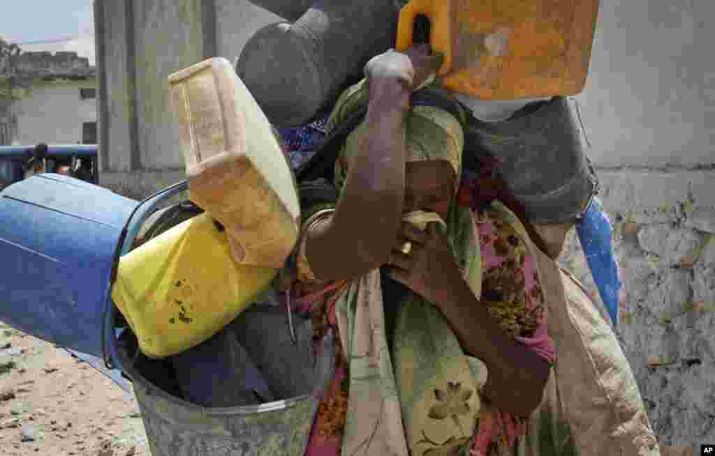 A Somali woman carries her belongings as she flees from the Heliwa district in the north of the capital Mogadishu, Somalia. Residents in Mogadishu sayid that hundreds of families were fleeing the capital after a spike in the number of clashes between militants and pro-government troops.