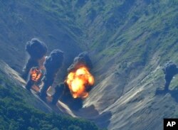 In this photo provided by South Korea Defense Ministry, bombs dropped by U.S. Air Force B-1B bombers, F-35 stealth fighter jets and South Korean F-15 fighter jets hit a simulated target as they fly over the Korean Peninsula