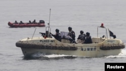 Anti-Terrorist Units of the Philippine and Japanese Coast Guards (R) prepare to target a vessel and engage the mock pirates during a combined maritime law enforcement exercise at a bay in Manila, May 6, 2015.