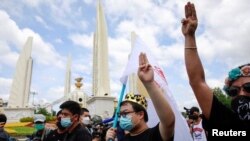 Protest leader Parit "Penguin" Chiwarak (with crown) shows the three-finger salute during a demonstration to mark the 89th anniversary of the abolition of absolute monarchy in Bangkok, Thailand, June 24, 2021. (Reuters)