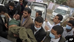 Medics carry an injured anti-government protester into a makeshift clinic in Sana'a, March 13, 2011