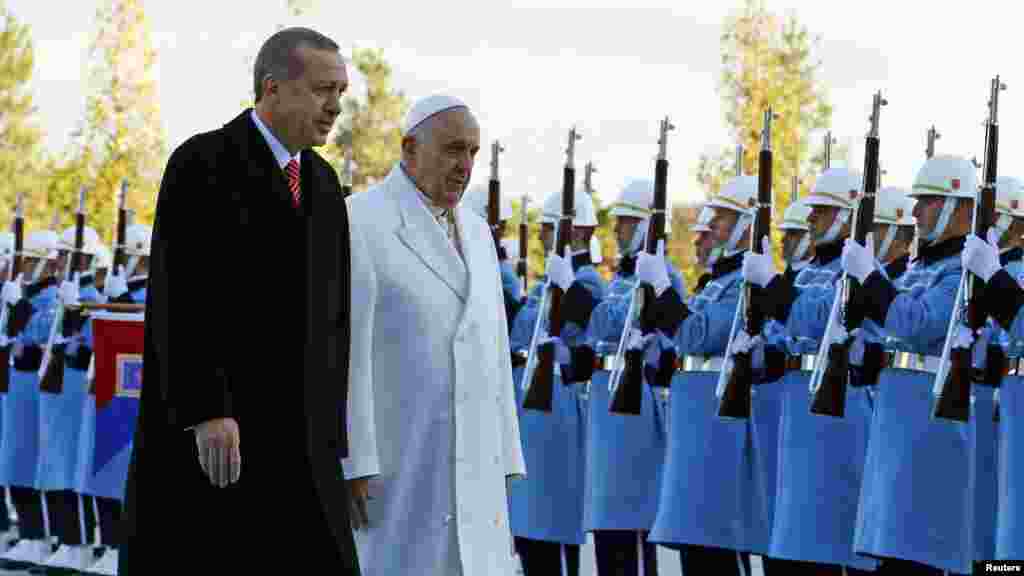 Pope Francis and Turkey's President Recep Tayyip Erdogan walk in front of honor guard at the presidential palace in Ankara, Nov. 28, 2014. 
