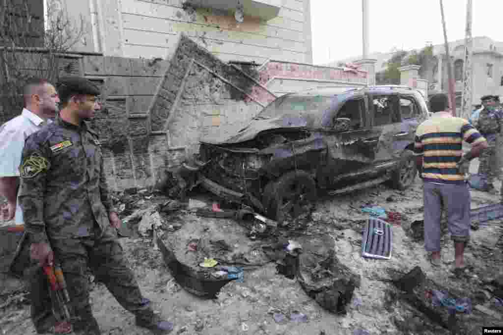 Iraqi security forces inspect the site of bomb attacks in Basra, Iraq, July 14, 2013. 