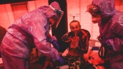 کادر درمانی در حال رسیدگی به یک بیمار مبتلا به کرونا در چادری که در کنار یک بیمارستان در شهر کاخوفکا، اوکراین بنا شده است - آرشیو