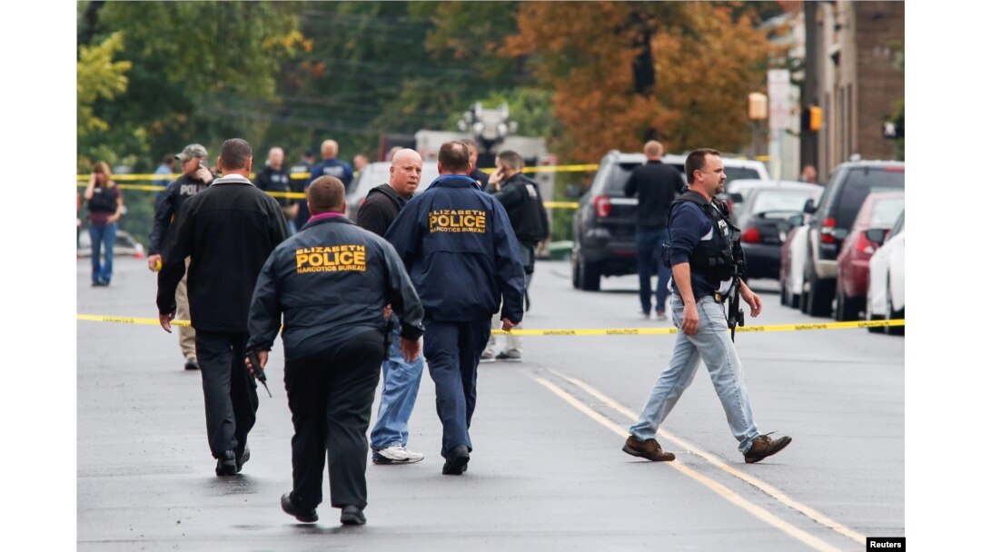 Police officers walk near the site where Ahmad Khan Rahami, sought in connection with a bombing in New York, was taken into custody in Linden, New Jersey, U.S., Sept. 19, 2016.