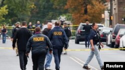 Des officiers de police marchent près de l'endroit où Ahmad Khan Rahami a été arrêté à New York, le 19 septembre 2016.