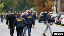 Des officiers de police marchent près de l'endroit où Ahmad Khan Rahami a été arrêté à New York, le 19 septembre 2016. 