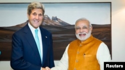 Menteri Luar Negeri John Kerry (kiri) berjabat tang an dengan Perdana Menteri India Narendra Modi di kediaman Modi di New Delhi 1 Agustus 2014.