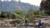 FILE - A fisherman casts his net near Don Sahong. The Laos government is planning a $600 million dam for the area. (L. Hunt/VOA) 